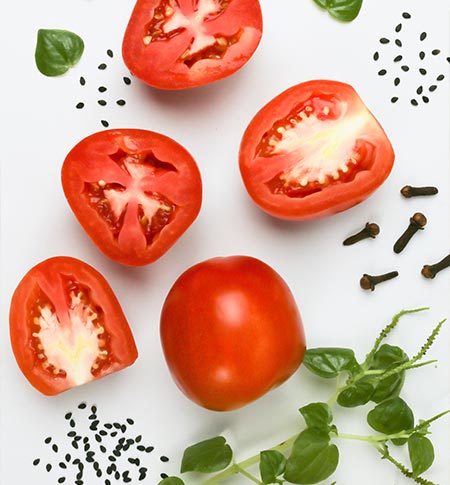red tomatoes green herbs and seeds depicting healthy nutrition