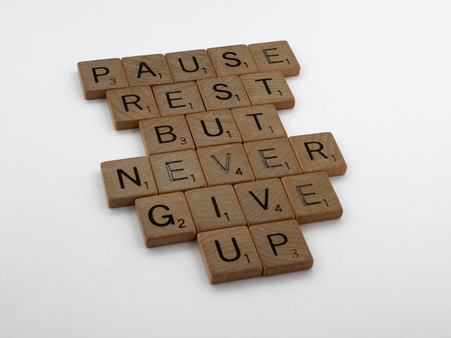 Scrabble tiles saying Pause rest but never give up in support to the article - Having trouble losing weight.